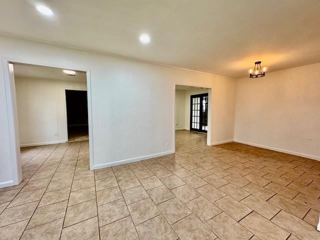 empty room featuring light tile patterned flooring, recessed lighting, baseboards, and an inviting chandelier