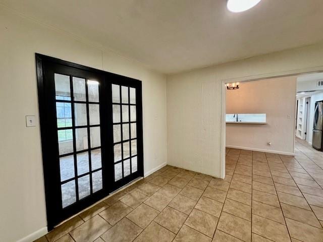 spare room with light tile patterned flooring, french doors, and baseboards