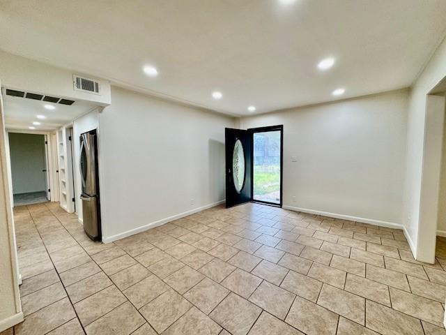 entryway with light tile patterned floors, baseboards, and visible vents