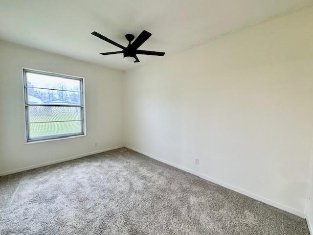 carpeted empty room featuring baseboards and ceiling fan