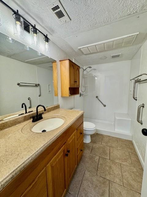 bathroom featuring visible vents, toilet, a stall shower, tile patterned floors, and vanity