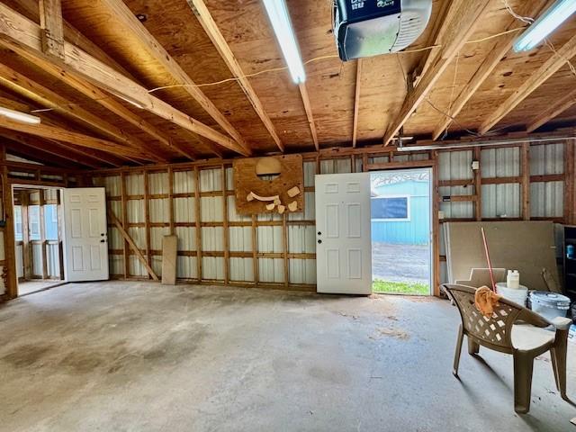 misc room featuring lofted ceiling, unfinished concrete flooring, and a garage