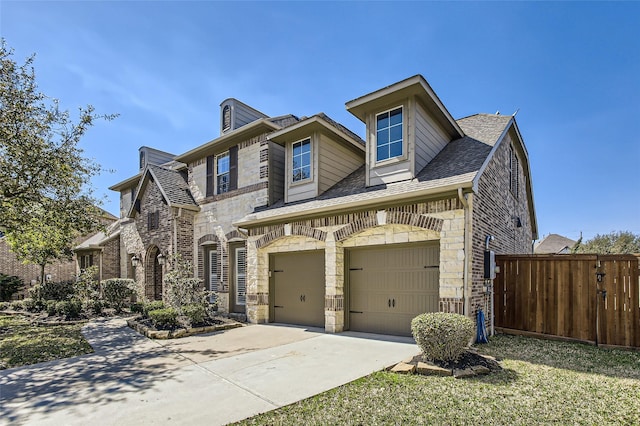 view of front of property featuring brick siding, stone siding, an attached garage, and concrete driveway