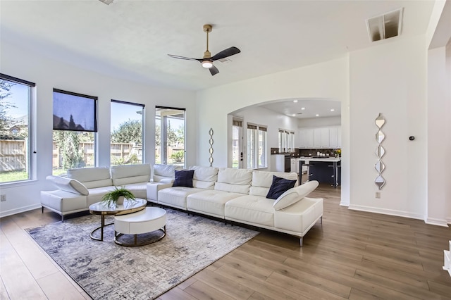 living area with a wealth of natural light, baseboards, and wood finished floors