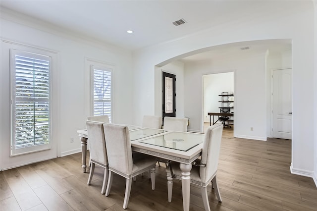 dining space with visible vents, wood finished floors, recessed lighting, arched walkways, and baseboards