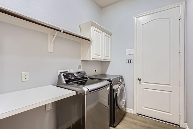 clothes washing area with baseboards, light wood-type flooring, cabinet space, and independent washer and dryer