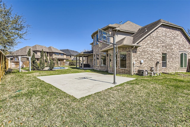 back of house featuring a patio, roof with shingles, a yard, a fenced backyard, and brick siding