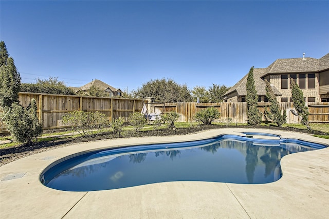 view of swimming pool featuring a fenced backyard and a pool with connected hot tub