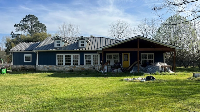 view of front of house with a standing seam roof, a front yard, and metal roof