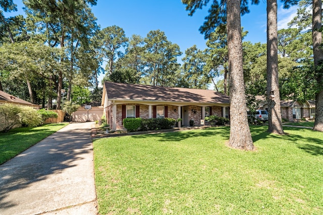 view of front facade with brick siding, a front lawn, and fence