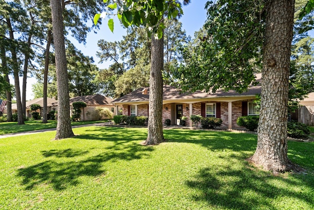 ranch-style home with brick siding, a front yard, and fence