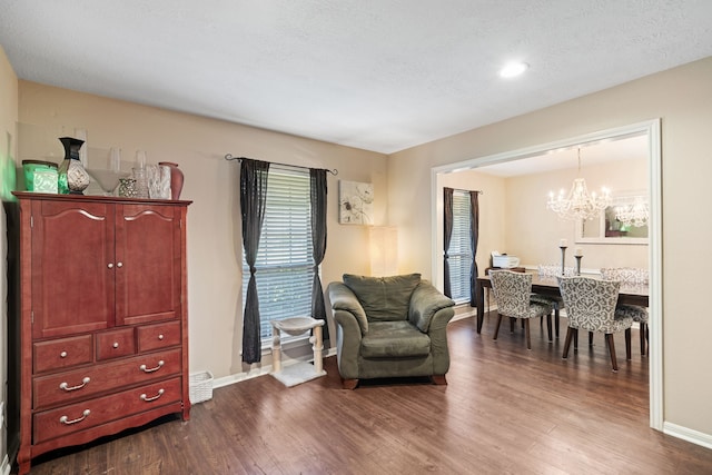 sitting room featuring a chandelier, baseboards, a textured ceiling, and dark wood finished floors