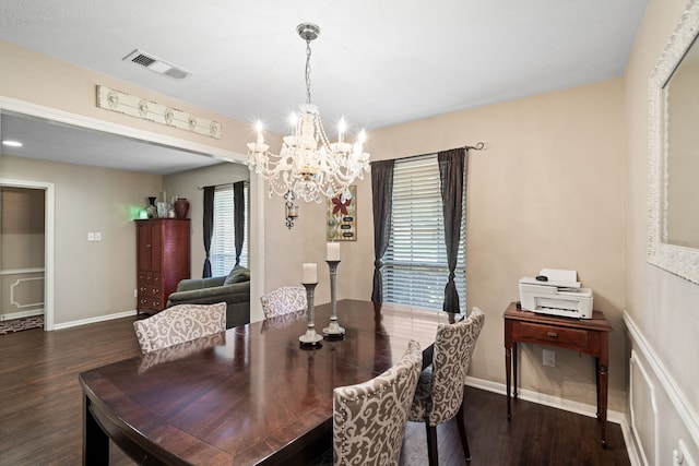 dining room with a notable chandelier, visible vents, baseboards, and dark wood-style flooring