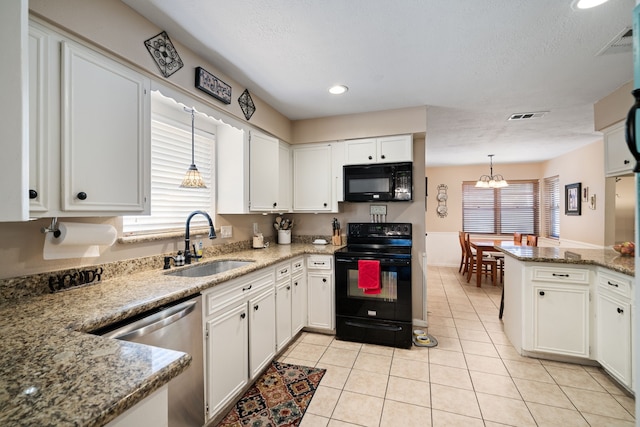 kitchen with visible vents, white cabinetry, black appliances, and a sink