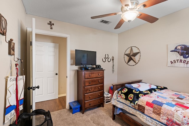 carpeted bedroom with visible vents and a ceiling fan