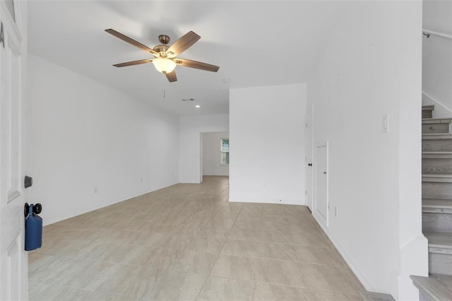 unfurnished room with stairway and ceiling fan