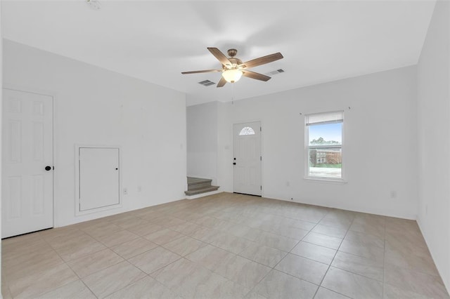 foyer entrance with stairs, light tile patterned floors, a ceiling fan, and visible vents