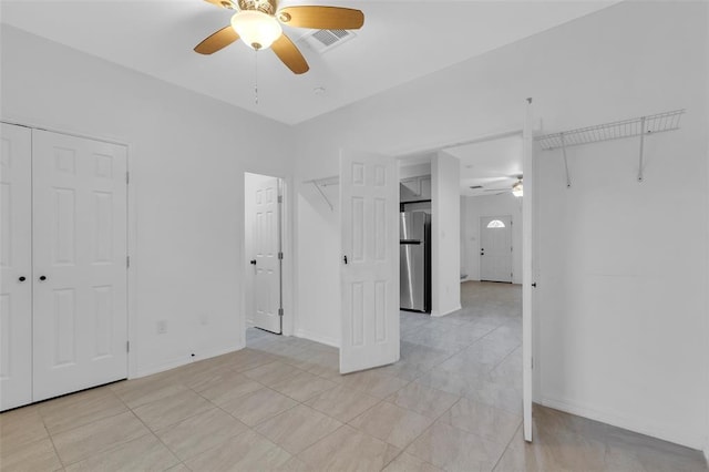 unfurnished bedroom with visible vents, baseboards, freestanding refrigerator, a closet, and a ceiling fan