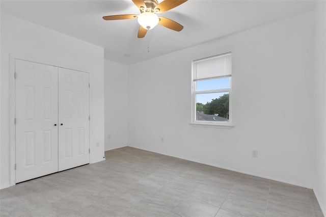 unfurnished bedroom featuring a ceiling fan, a closet, and baseboards