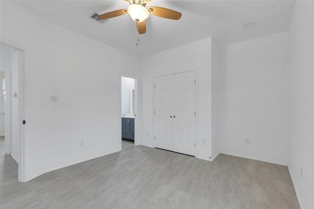 spare room with a ceiling fan, visible vents, and baseboards