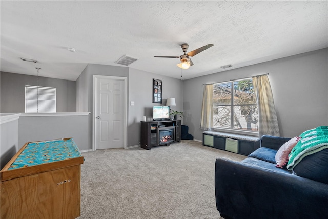 living room featuring baseboards, visible vents, a textured ceiling, and carpet