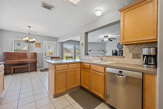 kitchen featuring visible vents, a sink, stainless steel dishwasher, backsplash, and light tile patterned floors