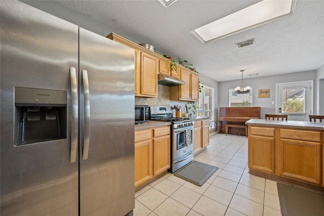 kitchen featuring light tile patterned floors, visible vents, decorative backsplash, under cabinet range hood, and appliances with stainless steel finishes