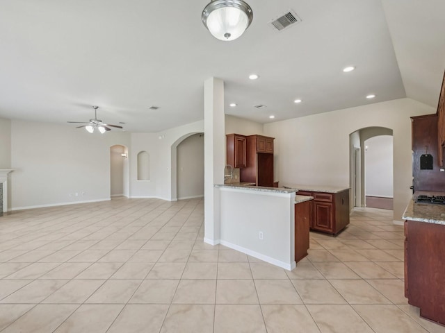 kitchen featuring visible vents, ceiling fan, light tile patterned flooring, arched walkways, and gas cooktop