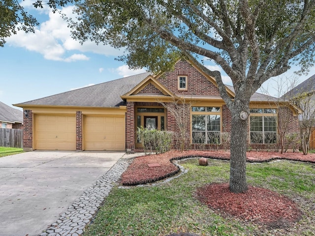 view of front facade with brick siding, an attached garage, concrete driveway, and fence