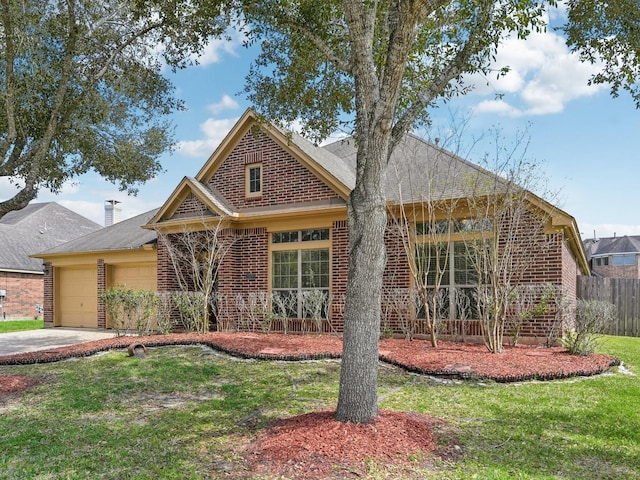 view of front of house featuring a front yard, a garage, fence, and brick siding