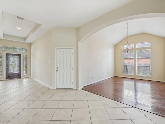 foyer featuring visible vents, baseboards, a chandelier, arched walkways, and light tile patterned flooring