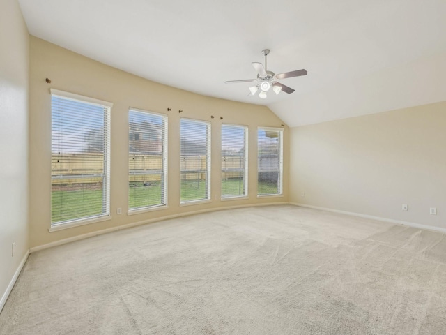 spare room with baseboards, light colored carpet, lofted ceiling, and a ceiling fan