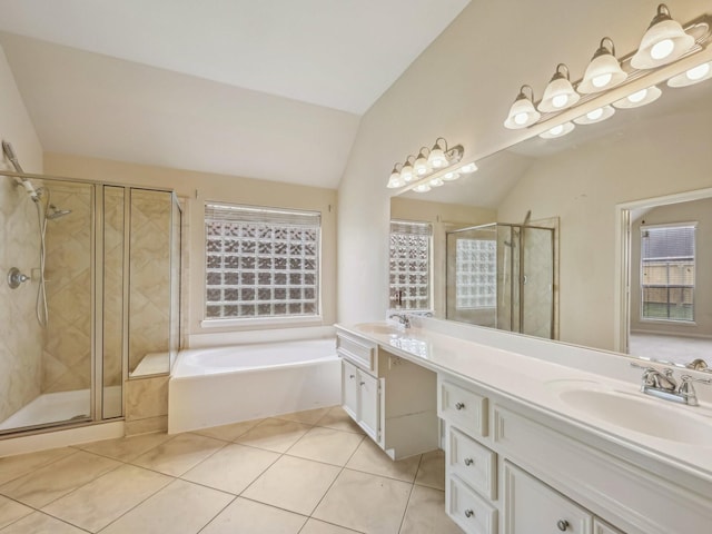 bathroom with tile patterned flooring, a shower stall, a garden tub, lofted ceiling, and a sink