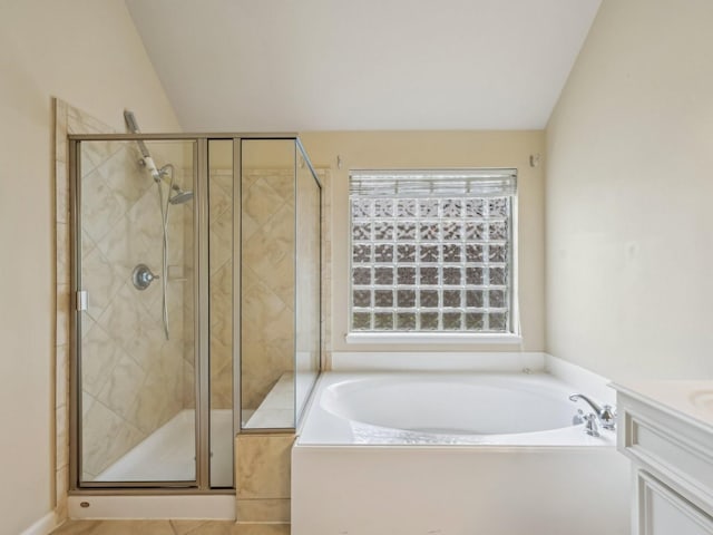 full bathroom with vanity, vaulted ceiling, a garden tub, and a shower stall