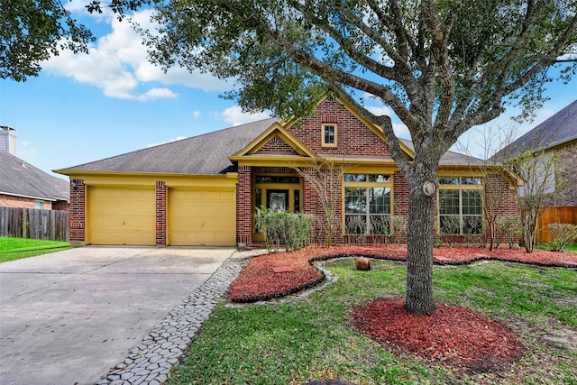 view of front facade with roof with shingles, driveway, brick siding, a garage, and fence