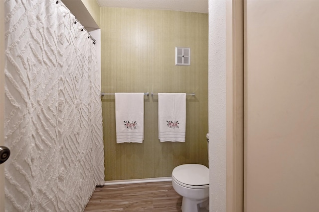 full bath featuring visible vents, baseboards, toilet, a shower with curtain, and wood finished floors