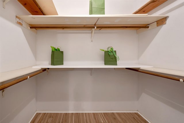 walk in closet with light wood-style floors