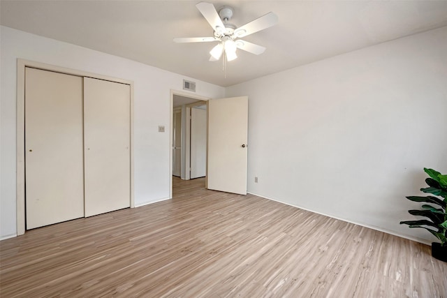 unfurnished bedroom with a closet, visible vents, light wood-style flooring, and a ceiling fan