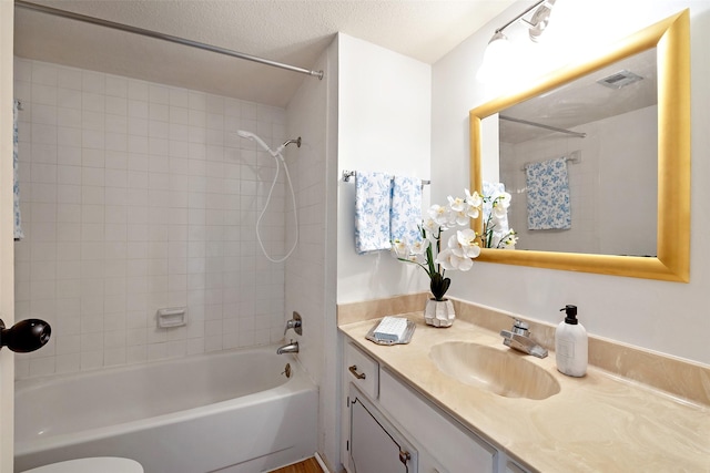 full bath featuring visible vents, toilet, a textured ceiling, shower / bathing tub combination, and vanity