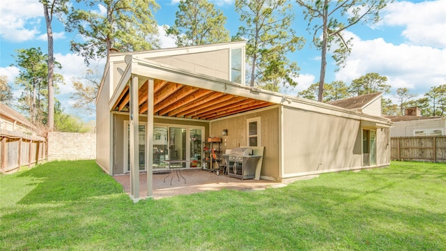 rear view of property featuring a yard, a patio area, and a fenced backyard