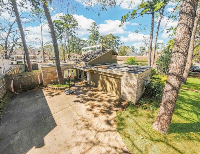 view of front facade featuring concrete driveway, fence, and a garage