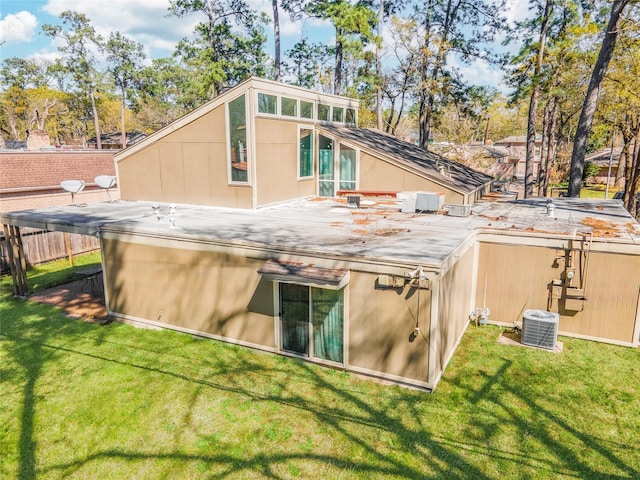 back of property with a lawn and fence