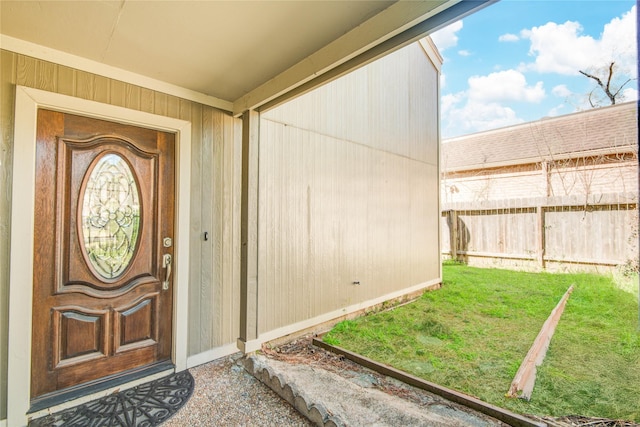 entrance to property with a lawn and fence