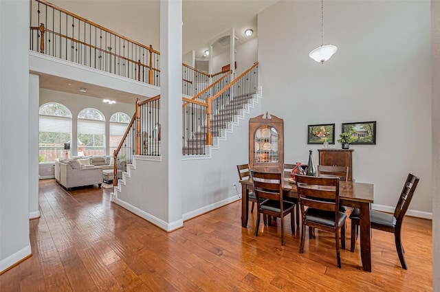 dining room featuring stairway, baseboards, and wood-type flooring