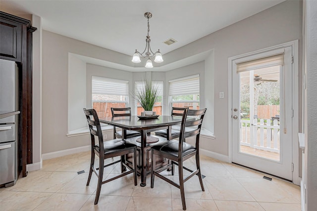 dining area featuring light tile patterned floors, visible vents, a notable chandelier, and baseboards