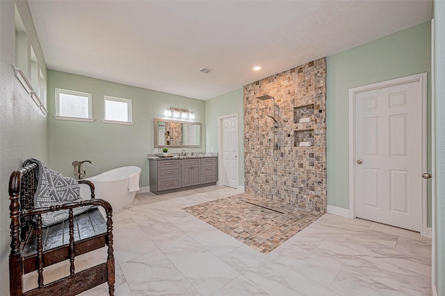 bathroom featuring a soaking tub, marble finish floor, a walk in shower, and vanity