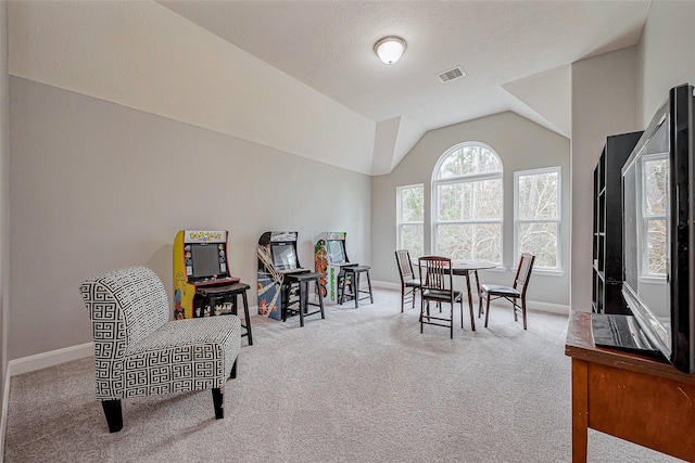 living area featuring lofted ceiling, carpet, visible vents, and baseboards