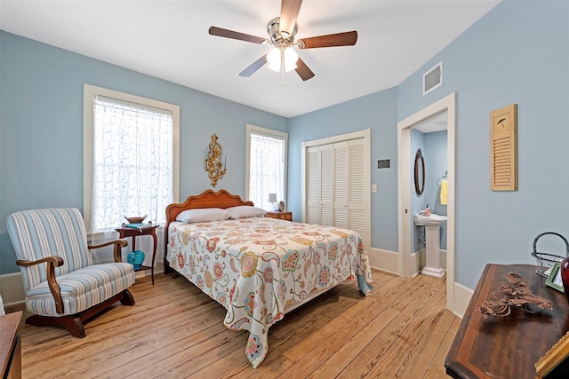 bedroom featuring visible vents, light wood-style flooring, a ceiling fan, a closet, and baseboards