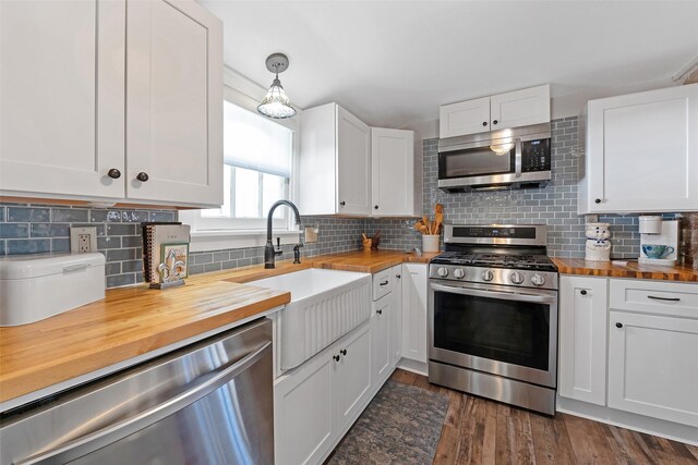 kitchen featuring a sink, dark wood-style flooring, appliances with stainless steel finishes, and butcher block counters