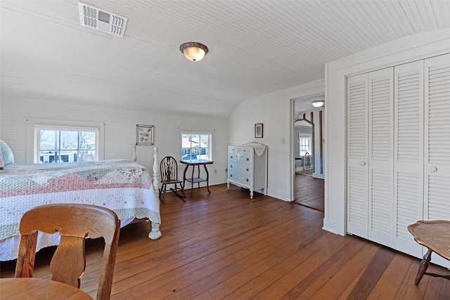 bedroom featuring vaulted ceiling, hardwood / wood-style flooring, visible vents, and a closet